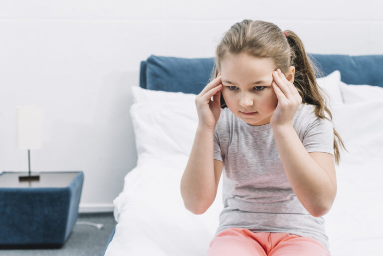 portrait girl sitting bed having headache 1